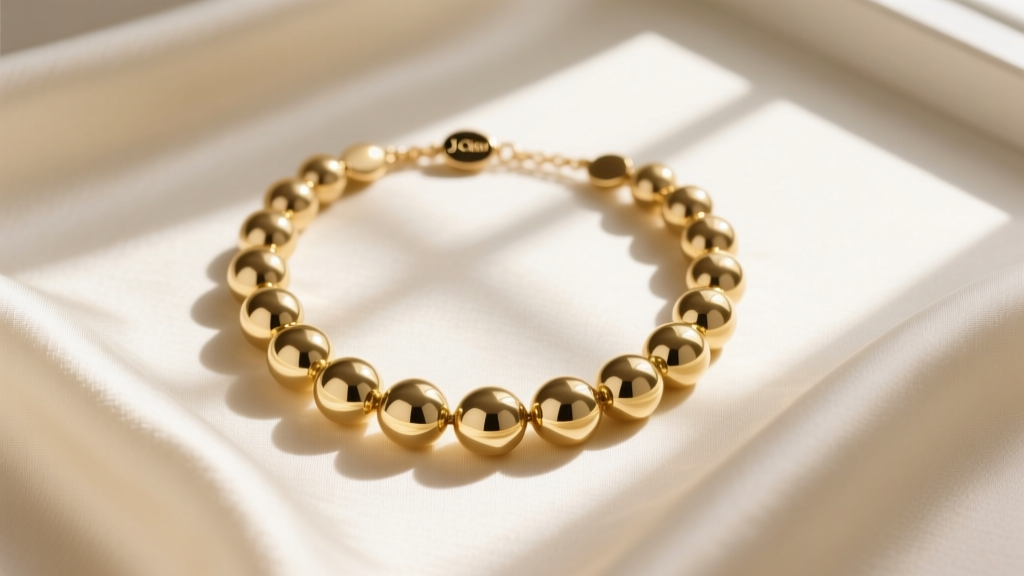 Overhead flat lay of a gold-tone J.Crew enamel bubble bib necklace resting on cream silk fabric under soft, natural window lighting.