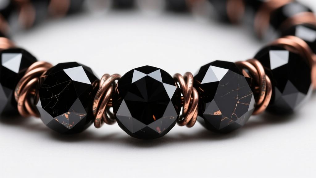 Macro shot of faceted black spinel beads wire-wrapped with 22-gauge darkened copper wire, highlighting sharp reflections