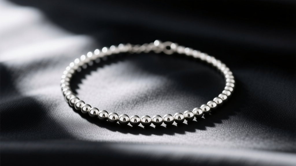 Vintage 90s 5mm sterling silver bead necklace on black silk, soft lighting highlighting metallic luster and subtle patina.
