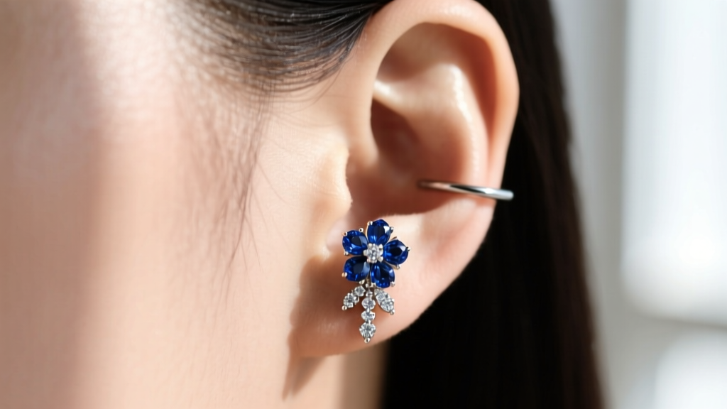 Close-up of a 16-gauge titanium flat piercing topped with a sapphire and diamond floral cluster on a model