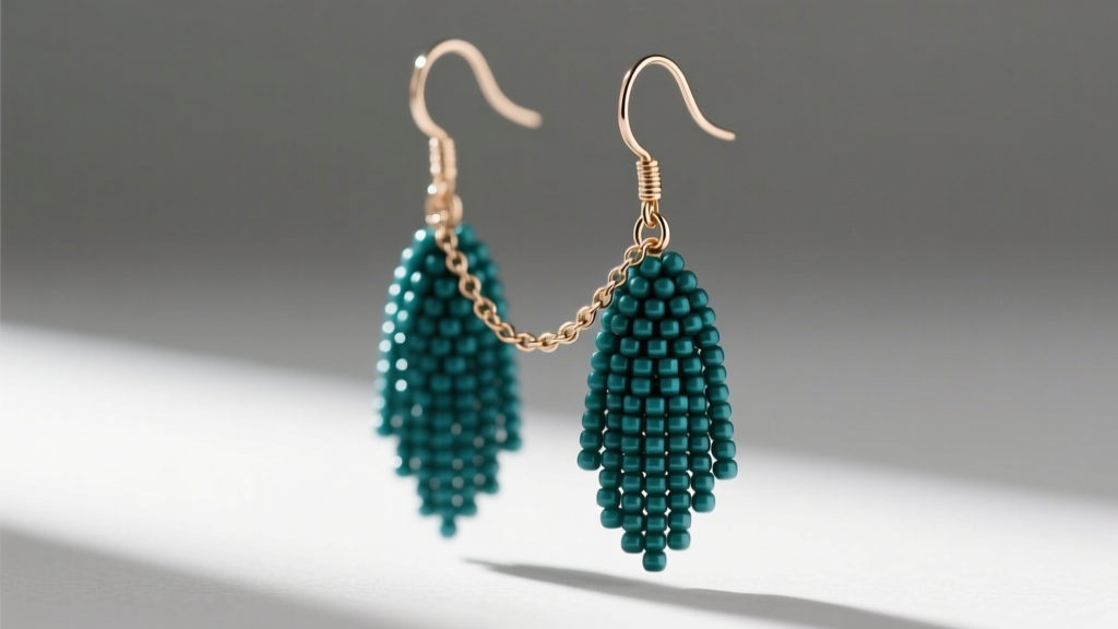 Close-up of intricate beaded fringe earrings with 11/0 Miyuki Delica beads in matte teal, hanging from 20-gauge niobium ear wires.