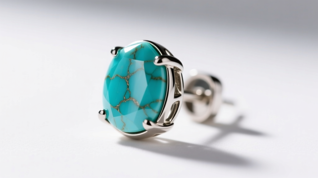 Macro photography showing a secure bezel setting holding a small turquoise stone chip earring in implant-grade titanium metal