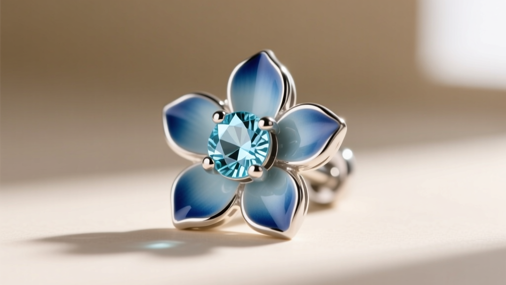 Macro shot of a sterling silver floral stud earring with a bezel-set light blue aquamarine center and cold blue enamel petals.
