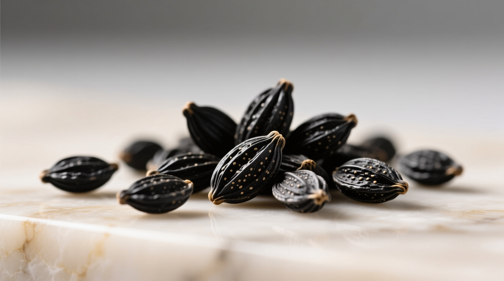 Close-up of raw Nigella sativa seeds showing their matte-black, teardrop shape against a wooden spoon