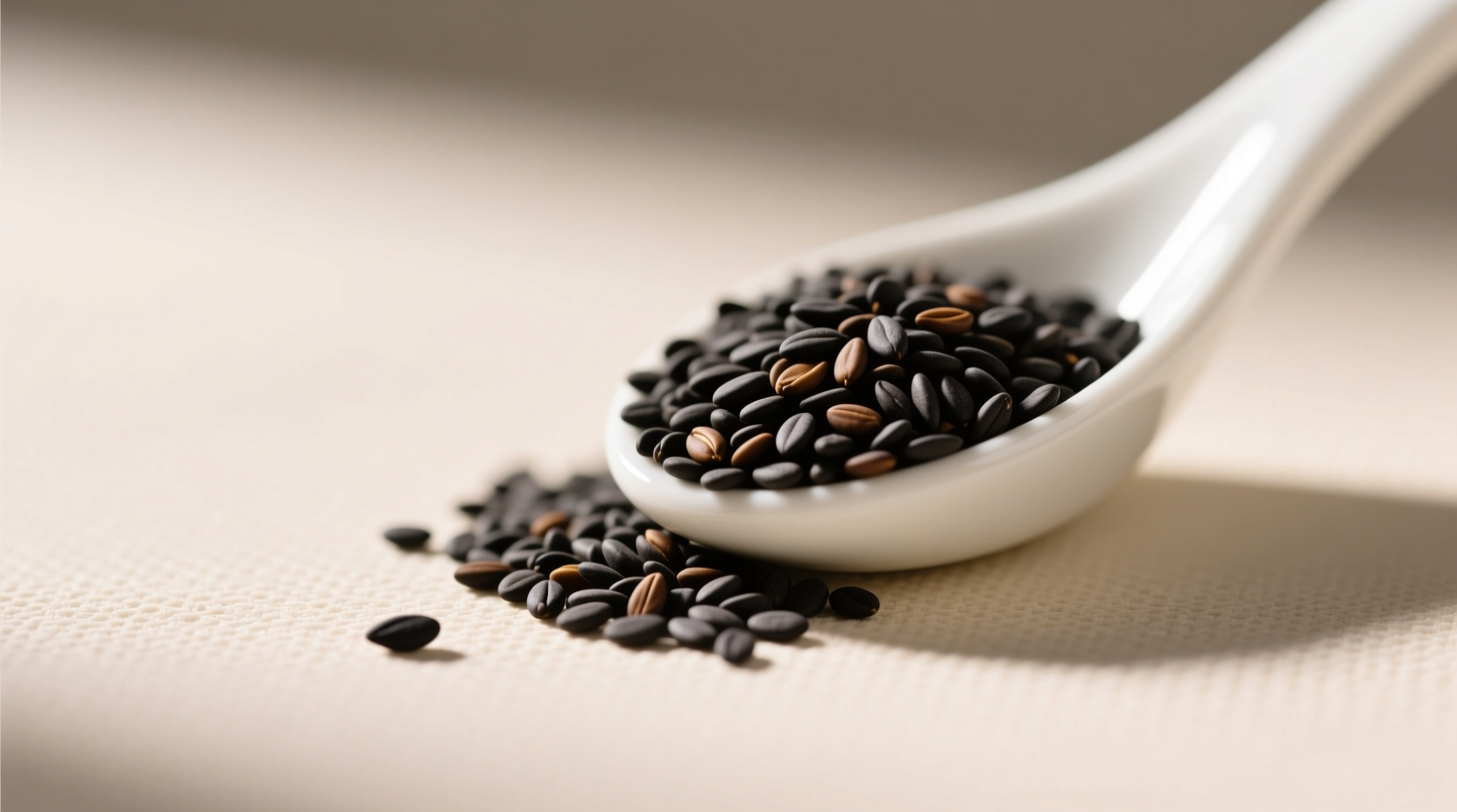Chef toasting black sesame seeds in a cast-iron pan, showing proper dry-heat technique to enhance flavor without burning