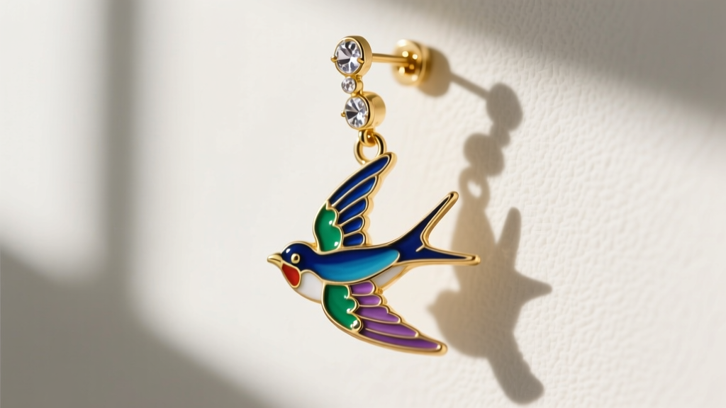 Macro shot of an 18-gauge gold vermeil leverback closure supporting an articulated enamel and crystal swallow bird dangle earring