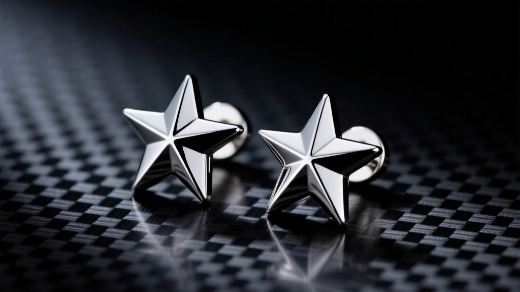 Close-up of polished implant-grade titanium Mercedes star stud earrings resting on dark carbon fiber with dramatic studio lighting.