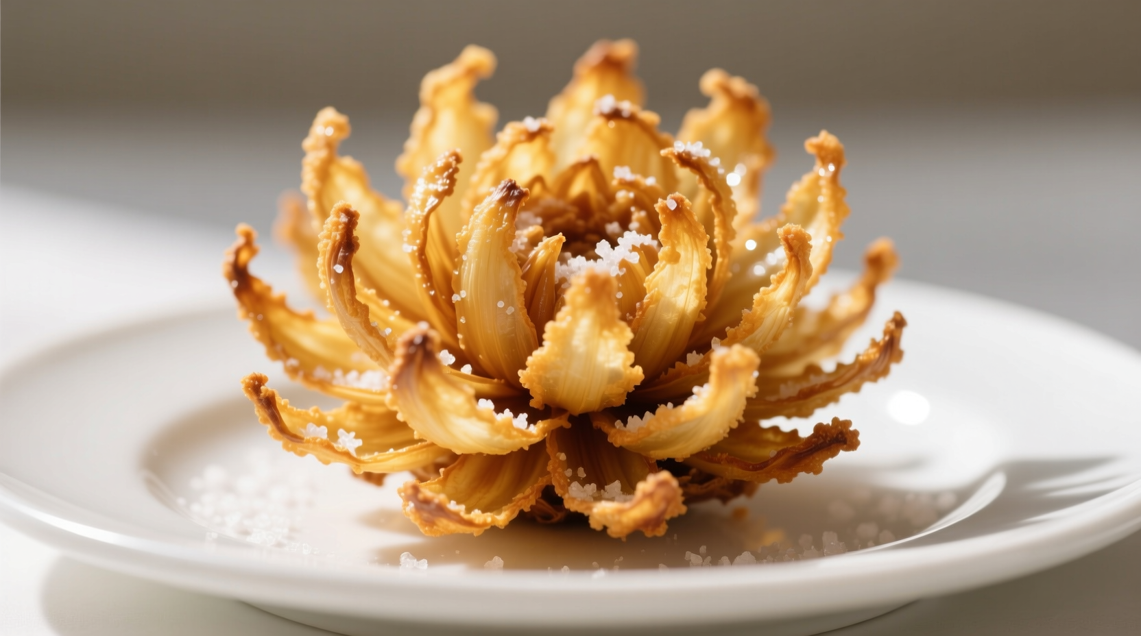 Crispy golden blooming onion on white plate