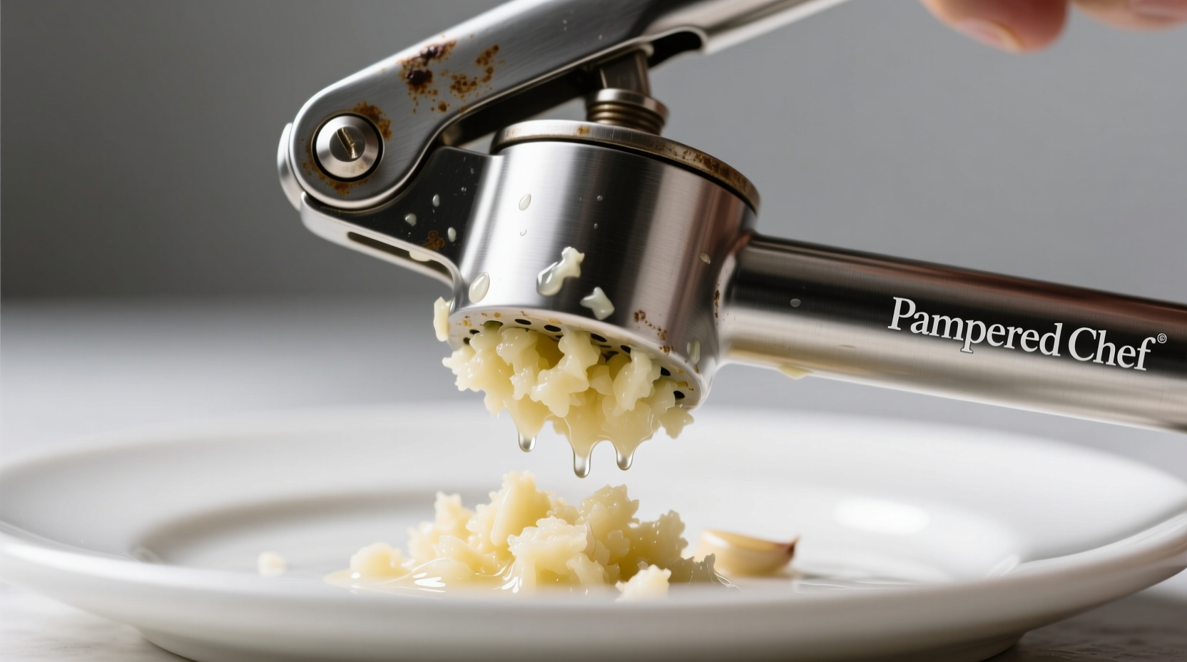 Pampered Chef garlic press extracting fresh garlic pulp