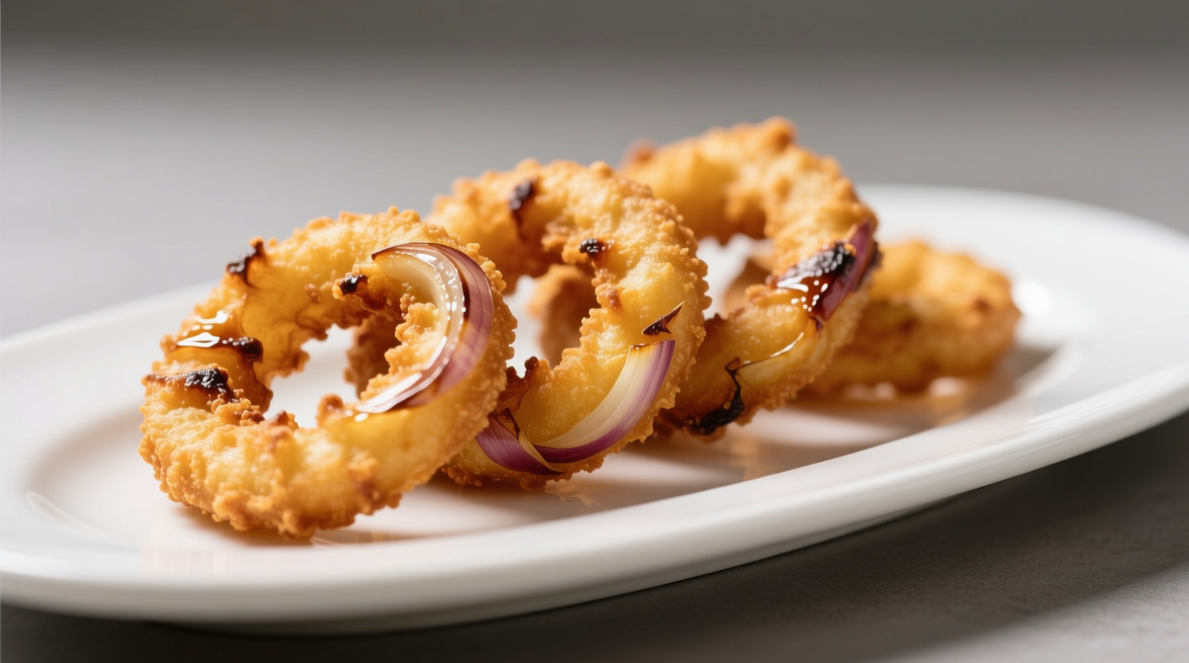 Golden brown onion rings with crispy texture on white plate