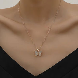 Colgante de mariposa dorada radiante con cristales pavé, disponible a precios de mayoreo. - Product Image 1