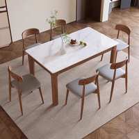 Table à manger rectangulaire en pierre frittée avec base en bois massif, style moderne et luxueux, idéale pour les petits appartements.