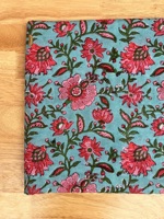 Kain katun murni premium dengan motif bunga berwarna merah muda cerah, pola bunga merambat yang indah dicetak di atas kain berwarna biru kehijauan lembut.