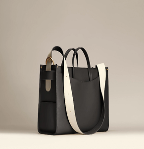 Bolso moderno de forma cuadrada en color negro con una correa en contraste blanco llamativa. Estilo chic disponible a precios de mayoreo. - Product Image 1
