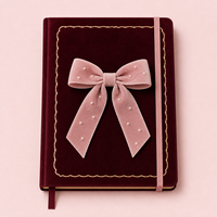 Carnet personnalisé LABON en velours bordeaux avec nœud, couverture rigide, accents nacrés, bordure festonnée dorée, bords dorés, bande élastique rose