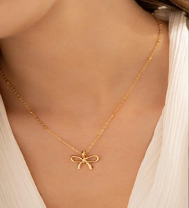 Colgante de lazo dorado dulce y elegante en una cadena de cuentas. Un accesorio encantador. Disponible a precios de mayoreo - Product Image 1