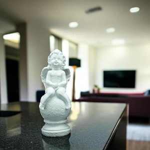 Estatua decorativa clásica para estante o mesa, figura de ángel querubín blanco sentado sobre una esfera texturada. - Product Image 1