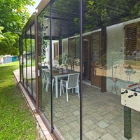 Pergola Aluminium Berwarna Cokelat Kustom dengan Pintu Kaca Tanpa Bingkai dan Pencahayaan LED untuk Taman Hunian di Marche, Italia
