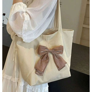 Sac fourre-tout minimaliste en toile poly crème avec un grand nœud nude, conçu pour un port féminin à l'épaule pour un usage quotidien - Product Image 1