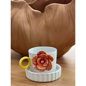 Tazza di rosa arancione con sottobicchiere