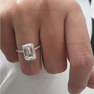 Anillo de compromiso de moissanita de corte esmeralda de lujo de 6 quilates en oro blanco con doble halo invisible de cuatro puntas y banda de media eternidad - Product Image 4