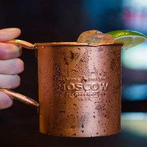 Fournit un gros plan d'un mug Moscow Mule en cuivre bien réfrigéré avec une condensation visible, mettant en évidence les cuivres de marque. - Product Image 1