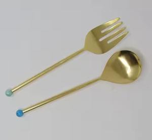 Élégant service à salade en or avec des têtes rondes plates, de longues poignées fines et des embouts en forme de boules de couleur parfaits pour une utilisation dans la cuisine moderne - Product Image 1