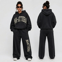 Ensemble survêtement streetwear deux pièces pour femme en molleton de coton uni, comprenant un sweat à capuche surdimensionné avec fermeture éclair et une veste à ceinture, et un pantalon de survêtement à jambes larges