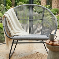 Fauteuil lounge d'extérieur gris tressé avec structure en métal et assise en corde, pour aménagement de terrasse, design artistique et décoration pure