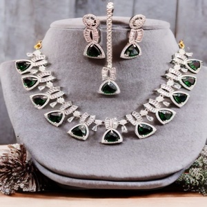 Ensemble collier et boucles d'oreilles en forme de larme Royale émeraude, composé de pierres vert émeraude encadrées de cristaux transparents étincelants - Product Image 1