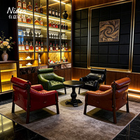 Fauteuil d'appoint moderne de luxe en cuir rouge, design capitonné avec appui-tête cylindrique et détails à boucles, pour salon, club ou bar