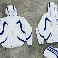 Fabricant de vêtements Streetwear : Survêtement coupe-vent personnalisé avec accent rayé géométrique contrastant, veste en nylon premium et pantalon ample
