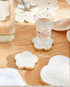 White marble coasters with a gold heart inlay, set on a woven placemat., available at wholesale prices. - Product Image 6