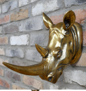 Añade un toque de la naturaleza salvaje a tu interior con este soporte de pared de rinoceronte dorado, resistente y con un aspecto envejecido. Disponible a precios de mayoreo. - Product Image 1