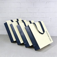 Emballage de bijoux en carton ivoire de luxe avec logo personnalisé, sac de shopping en papier épais pour vêtements