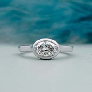 Hermoso Anillo de Compromiso con Diamante Ovalado Certificado por IGI, con Engaste Oeste-Oriental y Halo Oculto - Product Image 1