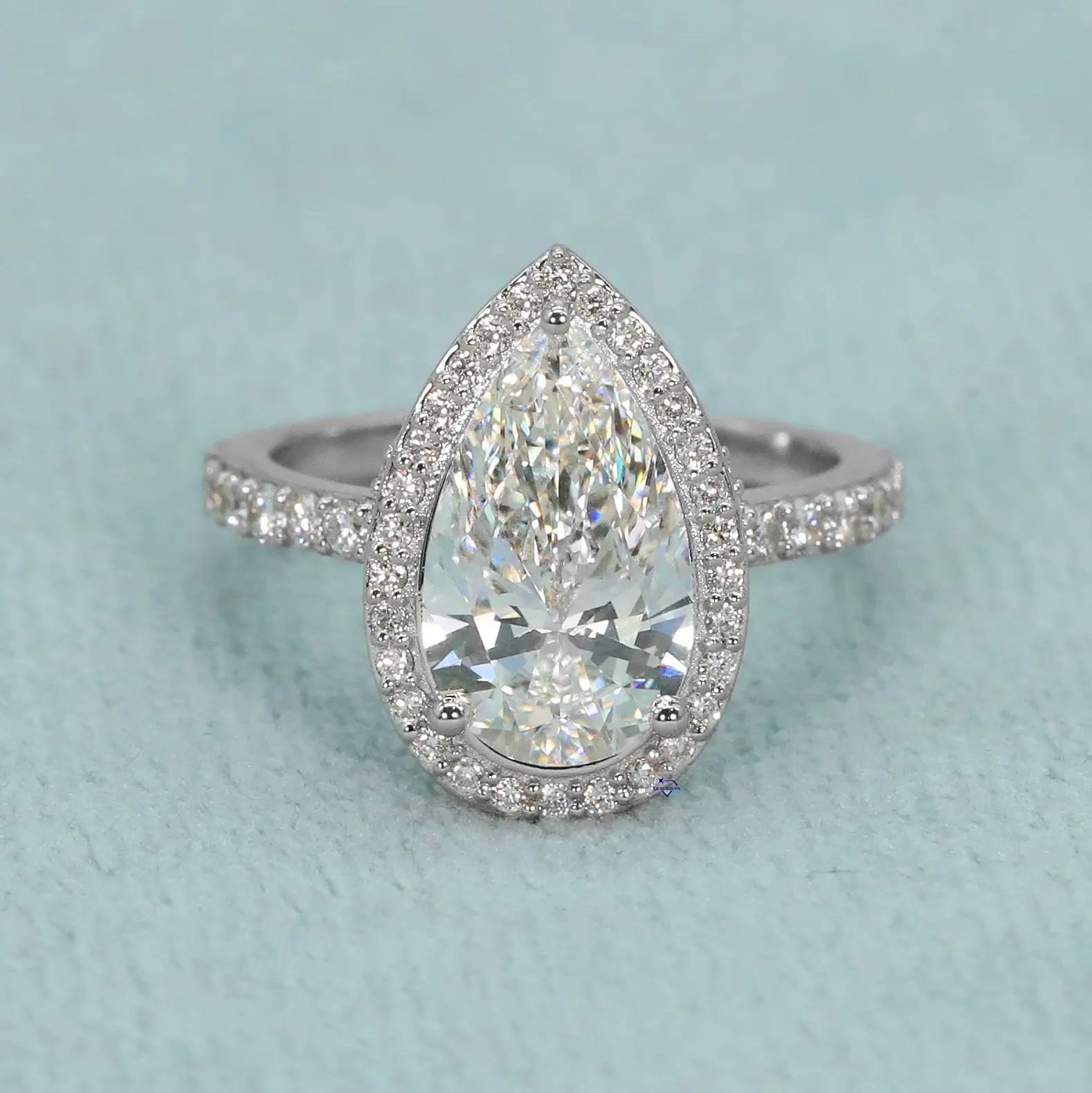 14kt white gold ring boasting a pear shaped moissanite diamond adding an enchanting touch of sophistication to their hands