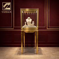 Vitrine à bijoux verticale avec éclairage LED, vitrine en verre hautement transparent, cadre en titane doré, design cubique, écologique