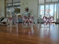 Taza de cristal transparente personalizable con lazo rosa y accesorio en forma de corazón con mango de cuentas