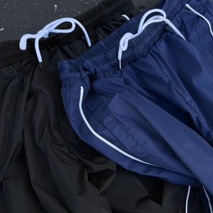 Pantalon de sport pour homme en polyester et nylon, personnalisé, décontracté, ample, pour la course à pied en plein air, séchage rapide, imperméable, avec bande latérale - Product Image 3