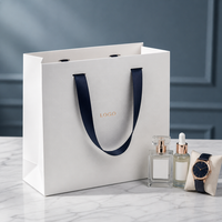 Sac shopping personnalisé en papier blanc avec logo en aluminium pour l'emballage de sérum de soin, de flacon de parfum et de montre