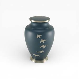 Soft Teal Blue Cremation Urn with Flying Bird Cutout Design and Silver Base for Symbolic Memorial - Product Image 1