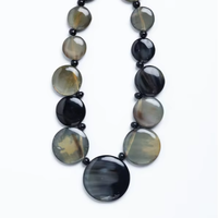 Ensemble de colliers en résine perlée polie au design moderne, d'inspiration artistique indienne exotique, avec collier disque réversible noir-naturel de Fashion Gallery