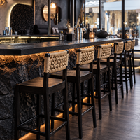 Ensemble de mobilier de restaurant avec banquettes et chaises en bois à dossier en rotin et tables noires pour café bistro