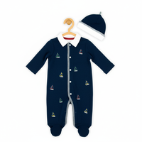 Pyjama bébé tricoté sur mesure bleu marine avec chaussons intégrés, fermeture à boutons-pression et bonnet brodé bateau à voile unique