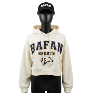 Haut à capuche court en molleton GSM premium pour femme, en tissu tricoté doux et chaud de couleur crème, avec logo personnalisé brodé et design frontal épuré. - Product Image 5