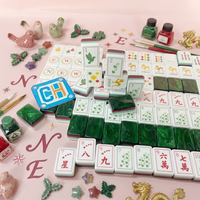 Ensemble de Mahjong de luxe vert émeraude avec dos marbré, côtés rayés et tuiles de jeu de Mahjong gravées avec des motifs botaniques