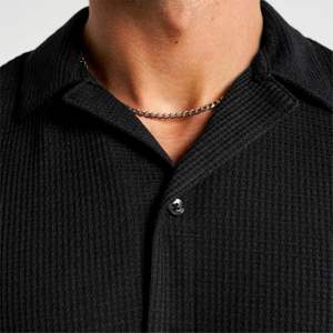 Chemise de coupe décontractée noire fabriquée avec un tissu texturé de qualité supérieure et des accents d'ourlet subtils pour un style décontracté moderne - Product Image 3