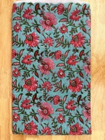 Kain katun murni premium dengan motif bunga berwarna merah muda cerah, pola bunga merambat yang indah dicetak di atas kain berwarna biru kehijauan lembut.