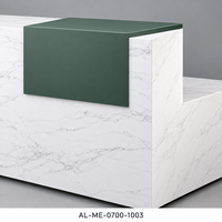 Bureau de réception en L en bois aspect marbre blanc avec accent vert foncé et façade grise côtelée pour projets de hall d'accueil de bureau moderne